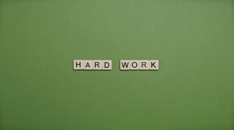 Tiles spelling 'hard work' on a green background symbolizing diligence and effort.