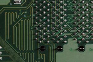 Detailed close-up of electronic circuit board with intricate green patterns and components.