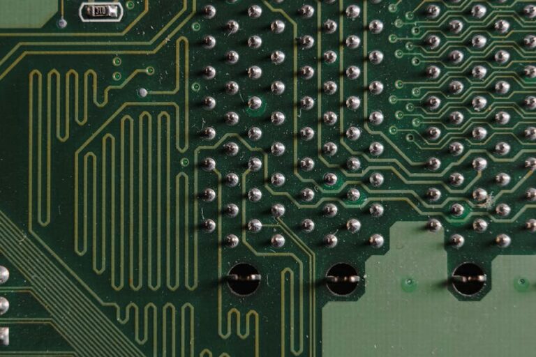 Detailed close-up of electronic circuit board with intricate green patterns and components.