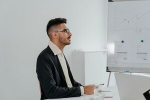Young businessman in a suit analyzing financial data during an office meeting.
