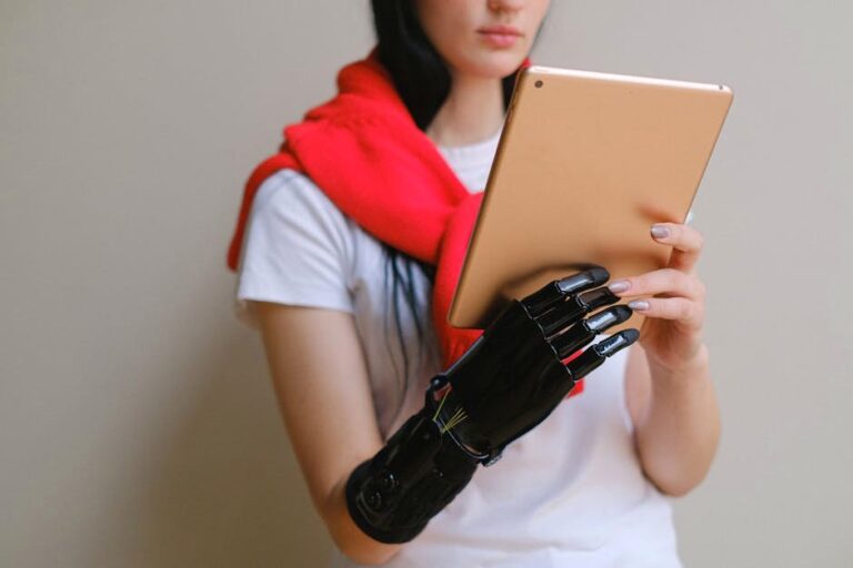 A woman with a bionic prosthetic arm uses a digital tablet indoors.