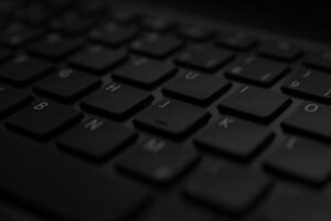 A detailed close-up of a black laptop keyboard with soft lighting and selective focus.