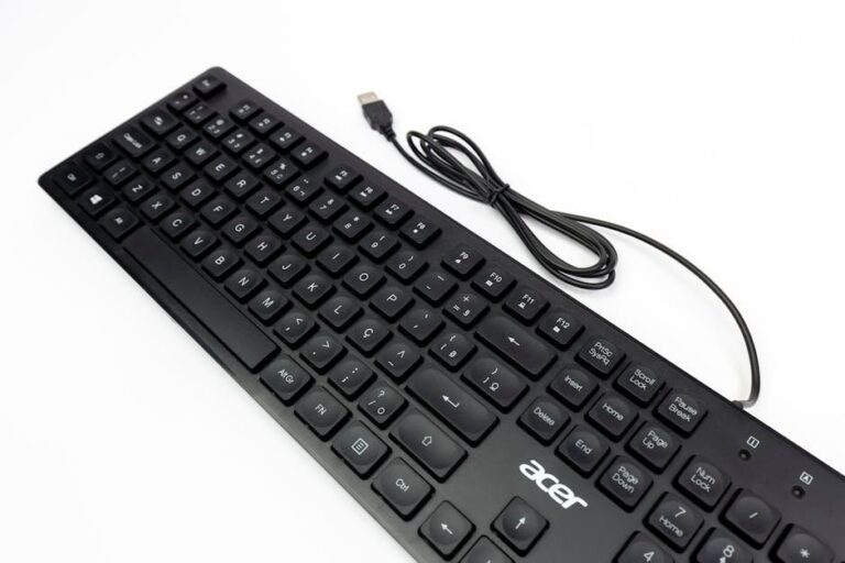 Top-down view of a black Acer keyboard with USB cable on a white backdrop, ideal for tech visuals.