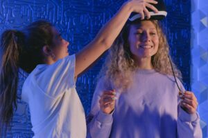 Two women having fun trying a virtual reality headset in a modern setting.