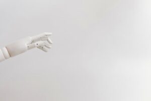 Minimalist image of a robotic hand reaching out on a white background.