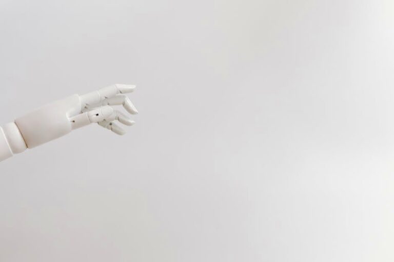 Minimalist image of a robotic hand reaching out on a white background.