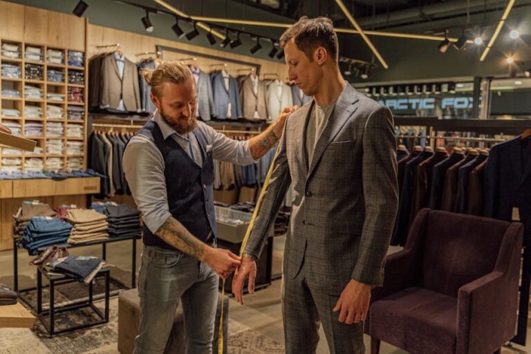 Tailor measuring a customer in a suit store for a perfect fit.