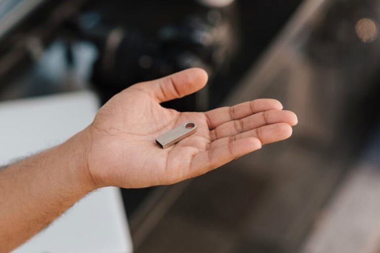 From above of crop anonymous male demonstrating modern portable memory device on palm of hand