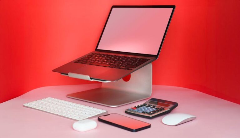 Sleek modern workspace with a laptop, keyboard, mouse, and calculator in a vibrant red setting.