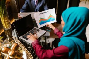 Muslim woman analyzing energy volume data during a business meeting.