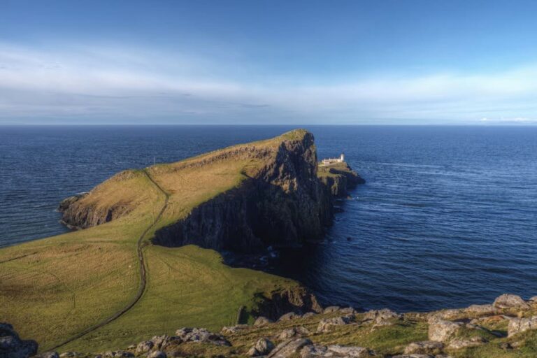 A breathtaking view of the Neist Point Lighthouse on the Isle of Skye, surrounded by ocean.