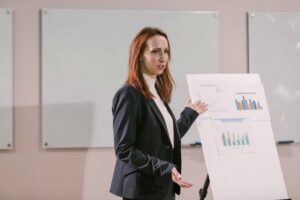 Confident businesswoman delivers presentation with charts at a professional conference.