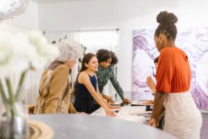 A diverse group of businesswomen discussing ideas together in a modern office setting.