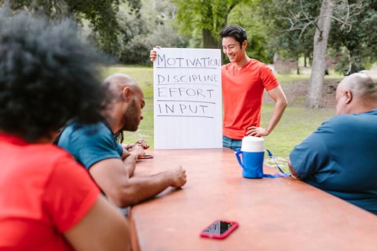 A diverse group of adults engaged in a motivational team building session outdoors.
