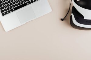 A flat lay of a laptop and VR headset on a clean surface, showcasing modern technology.