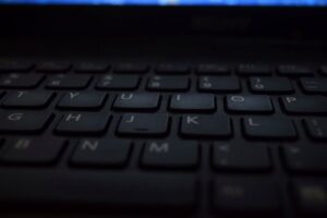 A close-up shot of a modern laptop keyboard with dim lighting, showcasing technology and design.