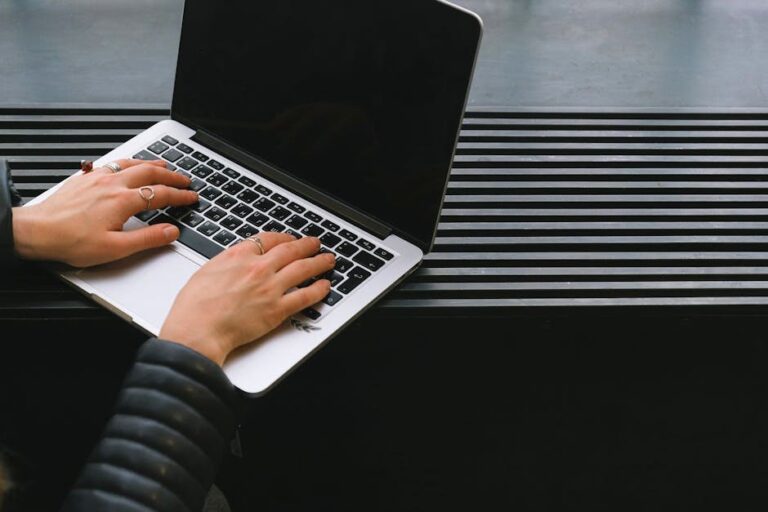 Close-up of hands typing on a sleek laptop, ideal for freelance work.