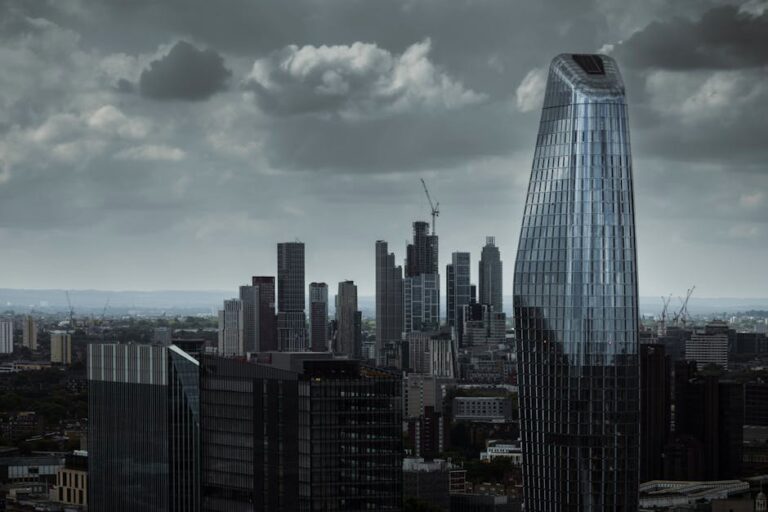 A dramatic view of London's skyline featuring modern architecture under a cloudy sky.