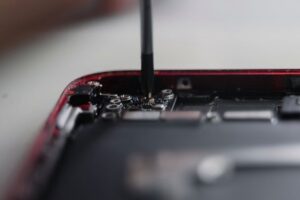 Professional repair of a smartphone's internal components using precise tools.