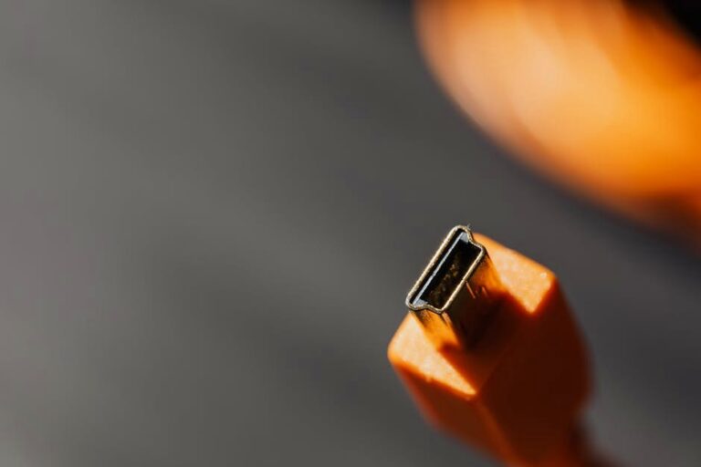 Detailed macro shot of an orange USB connector with a blurred background.