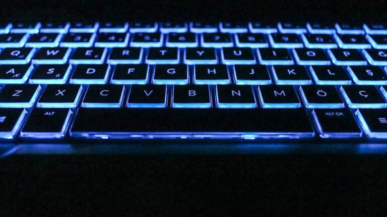 Close-up image of a glowing keyboard with blue backlighting, capturing modern technology essence.