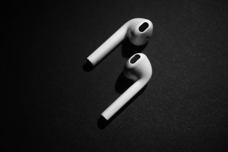 Close-up shot of white wireless earpods against a black background, showcasing modern technology.