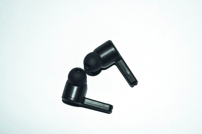 Close-up of stylish black earphones isolated on a white background, perfect for audio enthusiasts.