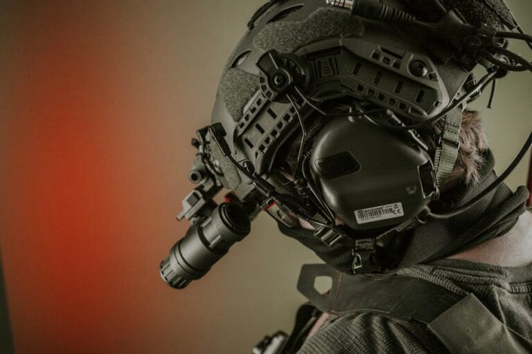Close-up of a person wearing advanced tactical gear and helmet for military use, with night vision attachment.