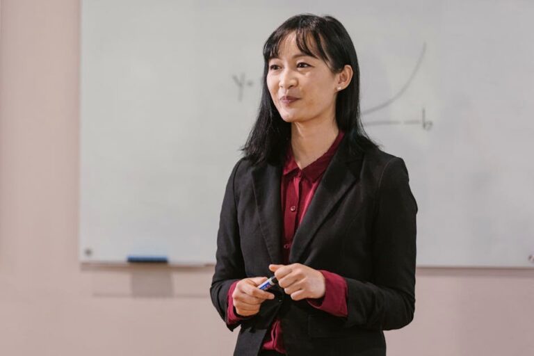 Professional woman presenting in a business meeting with a whiteboard.