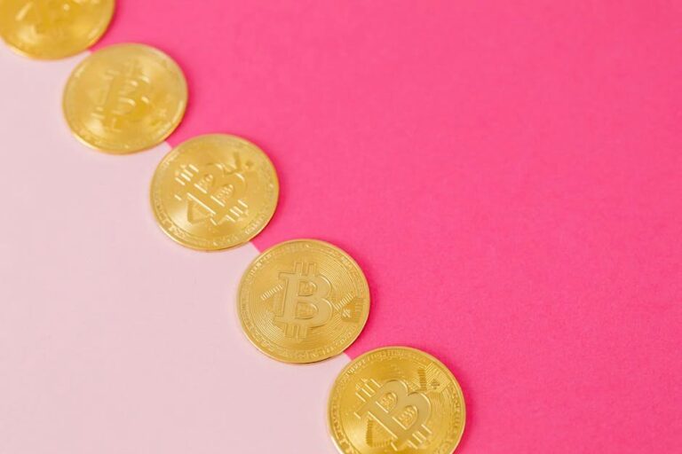 Array of gold bitcoin coins on a striking pink surface, symbolizing modern digital currency.