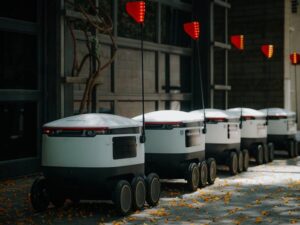 Futuristic delivery robots lined up in an urban environment, showcasing modern innovation.