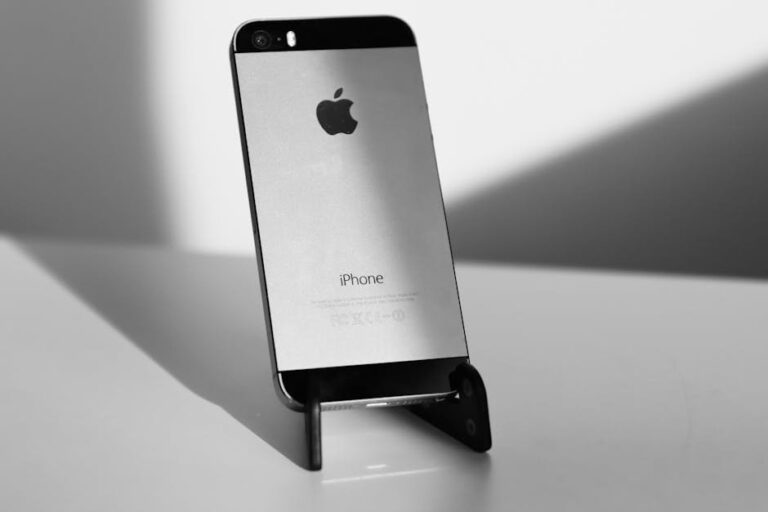 A sleek black and white close-up of an iPhone on a stand, highlighting minimalist design.