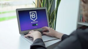 Close-up of hands on a laptop displaying a blockchain application, showcasing modern technology.