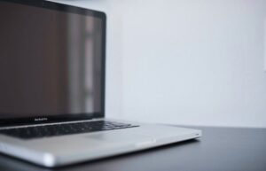 A sleek silver laptop on a modern desk against a white backdrop, perfect for work settings.