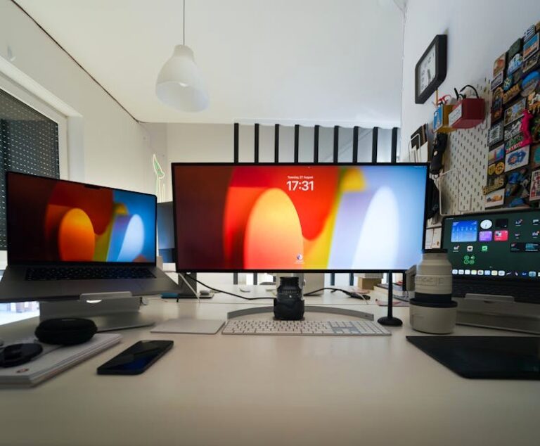 A sleek home office setup featuring multiple screens, laptops, and camera lenses on a white desk.