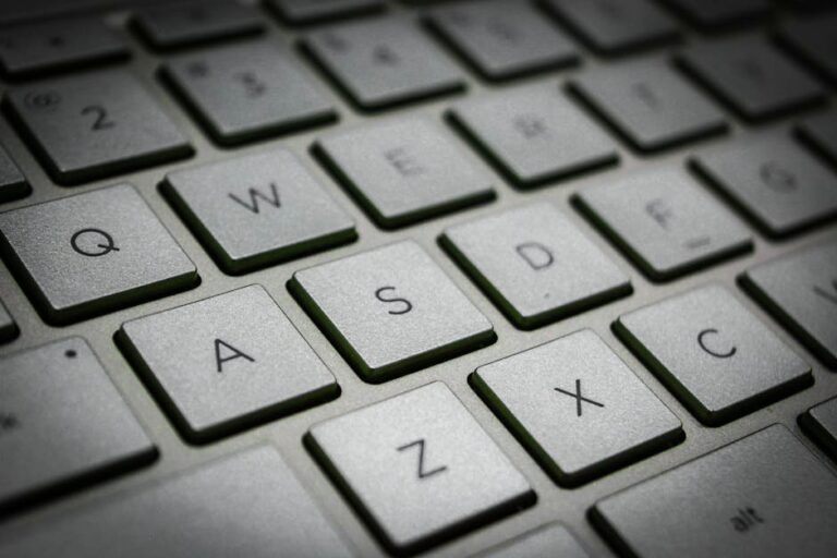 A detailed macro shot of a sleek modern computer keyboard featuring the QWERTY layout.