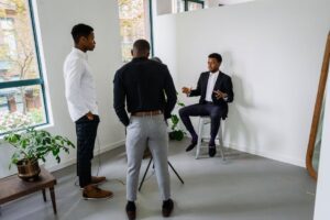 Three businessmen engaged in a meeting in a bright office space, discussing strategy.