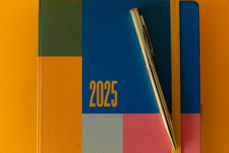 A vibrant 2025 planner with a pen on a colorful backdrop, ideal for organization.