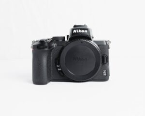 Black mirrorless camera displayed on a white backdrop, ideal for photography enthusiasts.