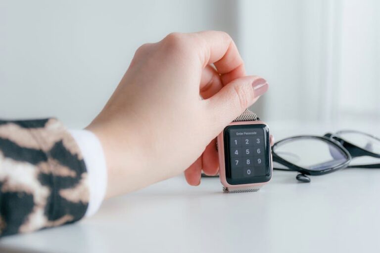 A close-up view of a hand interacting with a smartwatch on a desk, showcasing modern technology in use.
