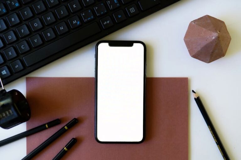 A sleek flat lay of a smartphone with office supplies, perfect for work-from-home themes.