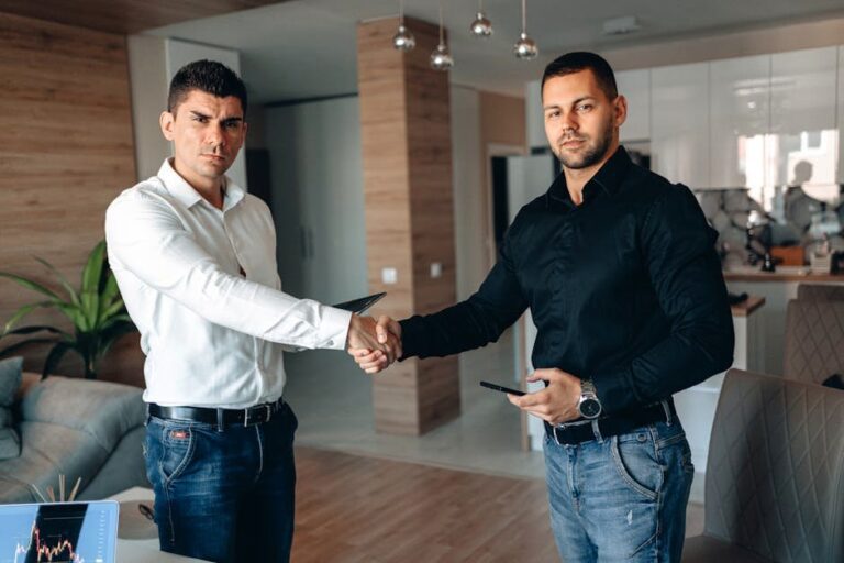 Two businessmen shaking hands in a modern office, symbolizing a successful business deal.