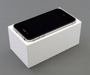 High-quality image of a smartphone placed on a white box, showcasing unboxing.
