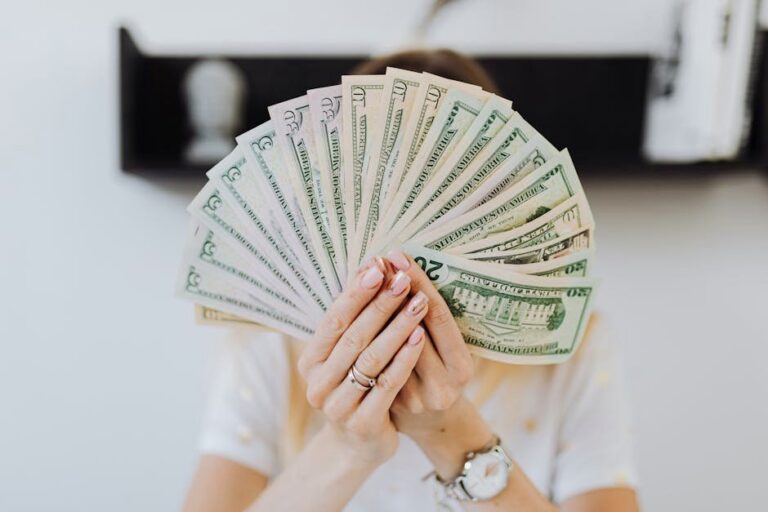 Close-up of hands holding a fan of US dollar bills, showcasing financial abundance.