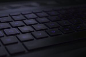Dark, moody close-up of black keyboard keys with soft lighting.
