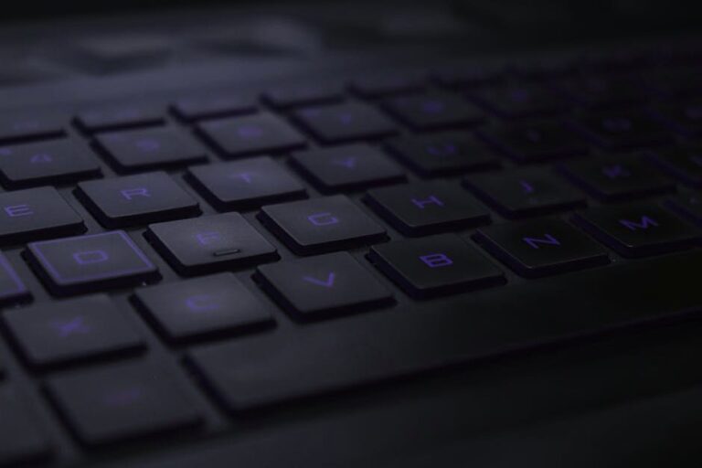 Dark, moody close-up of black keyboard keys with soft lighting.